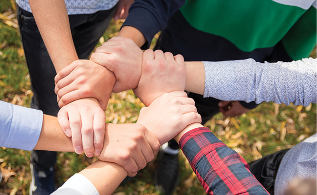 Community members joining hands in a circle, representing unity, collaboration, and shared commitment to positive change.