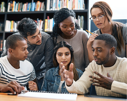 Six adults gather around a table in a library, sharing ideas and collaborating during a group discussion.